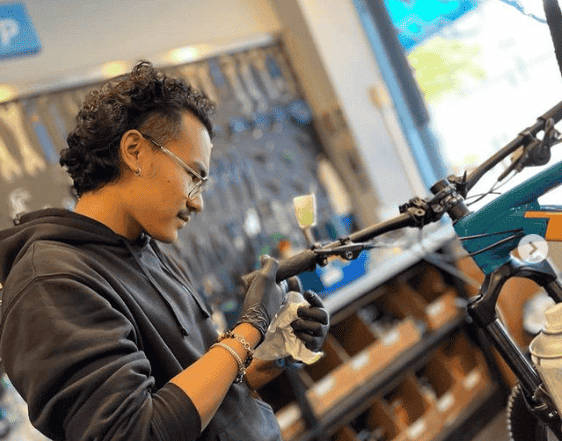 Mechanic working on bike handlebars in a bike workshop.